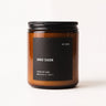 Smoke Season candle by NOT FRANKIE in amber glass jar, a warm smoky fragrance with chestnut, vanilla and wood notes, photographed on a clean white background.